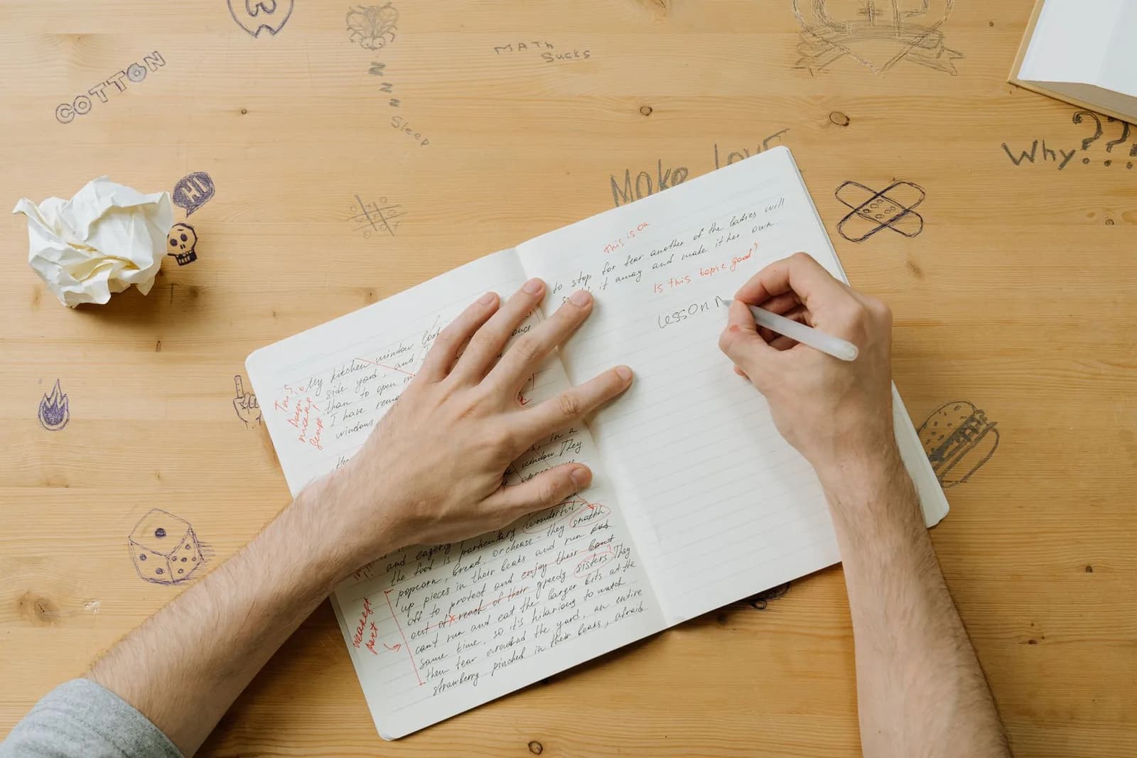 Notes, sketches and discarded drafts across a desk