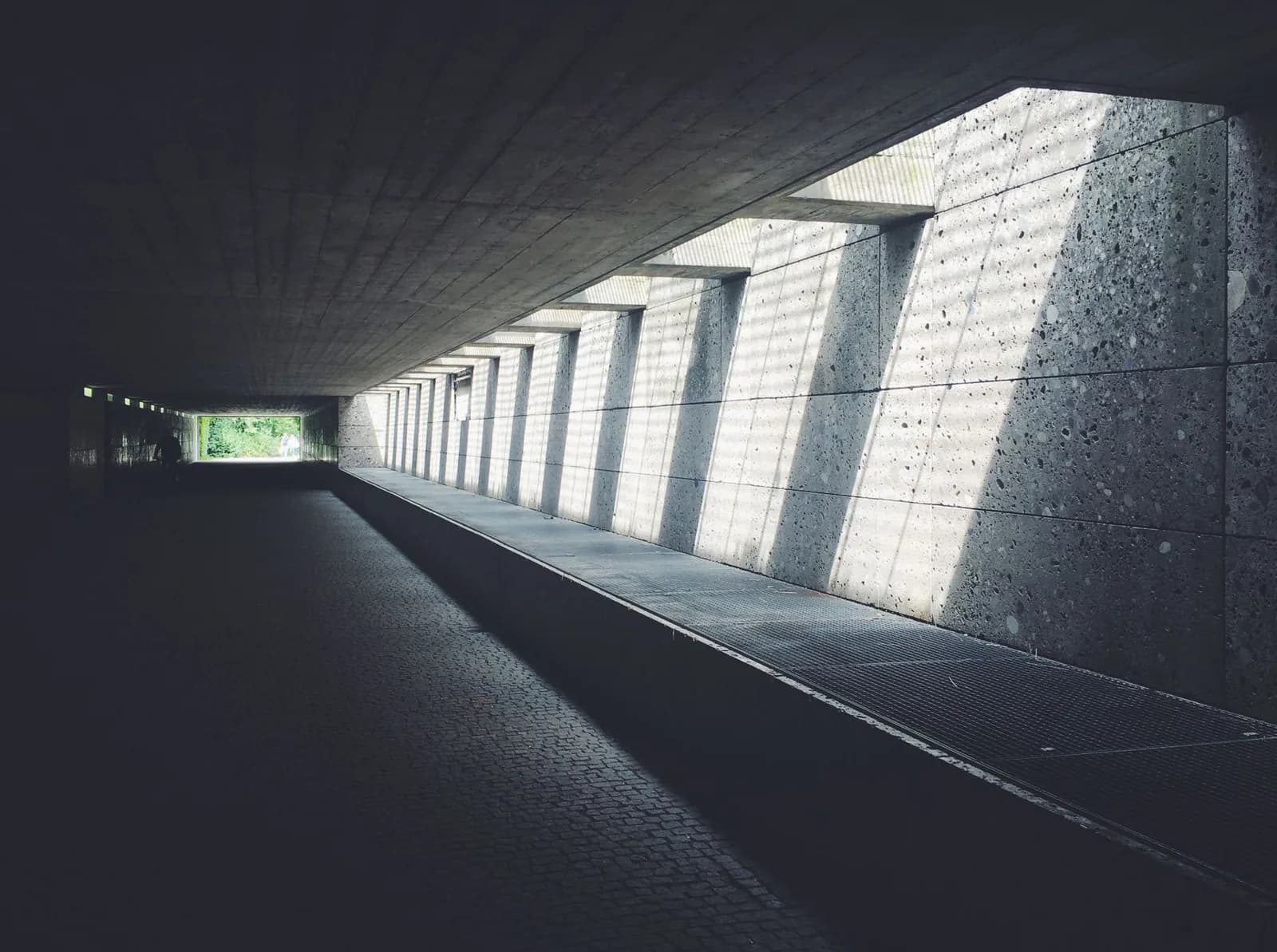 Concrete underpass receding toward daylight