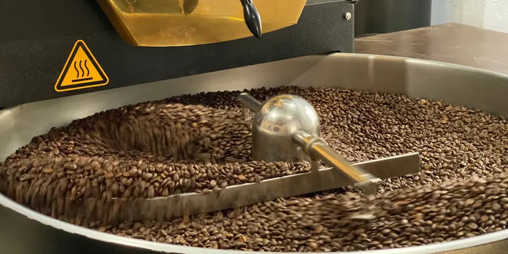 Roasted beans turning in the cooling tray of a coffee roaster